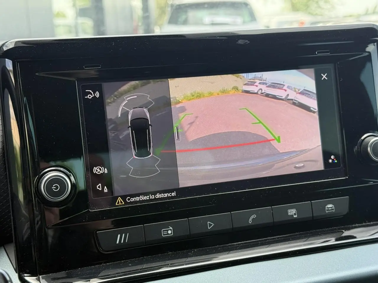 Écran de caméra de recul du SEAT Arona affichant l’aide au stationnement avec vue arrière et marquages verts et rouges.