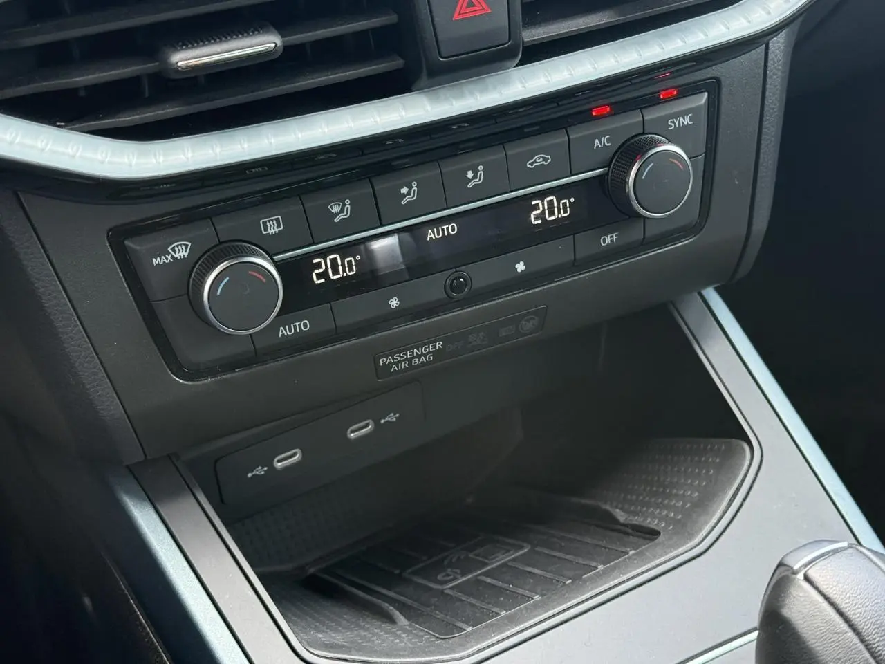 Vue rapprochée de la console centrale du SEAT Arona gris, montrant la climatisation automatique bi-zone et les ports USB.