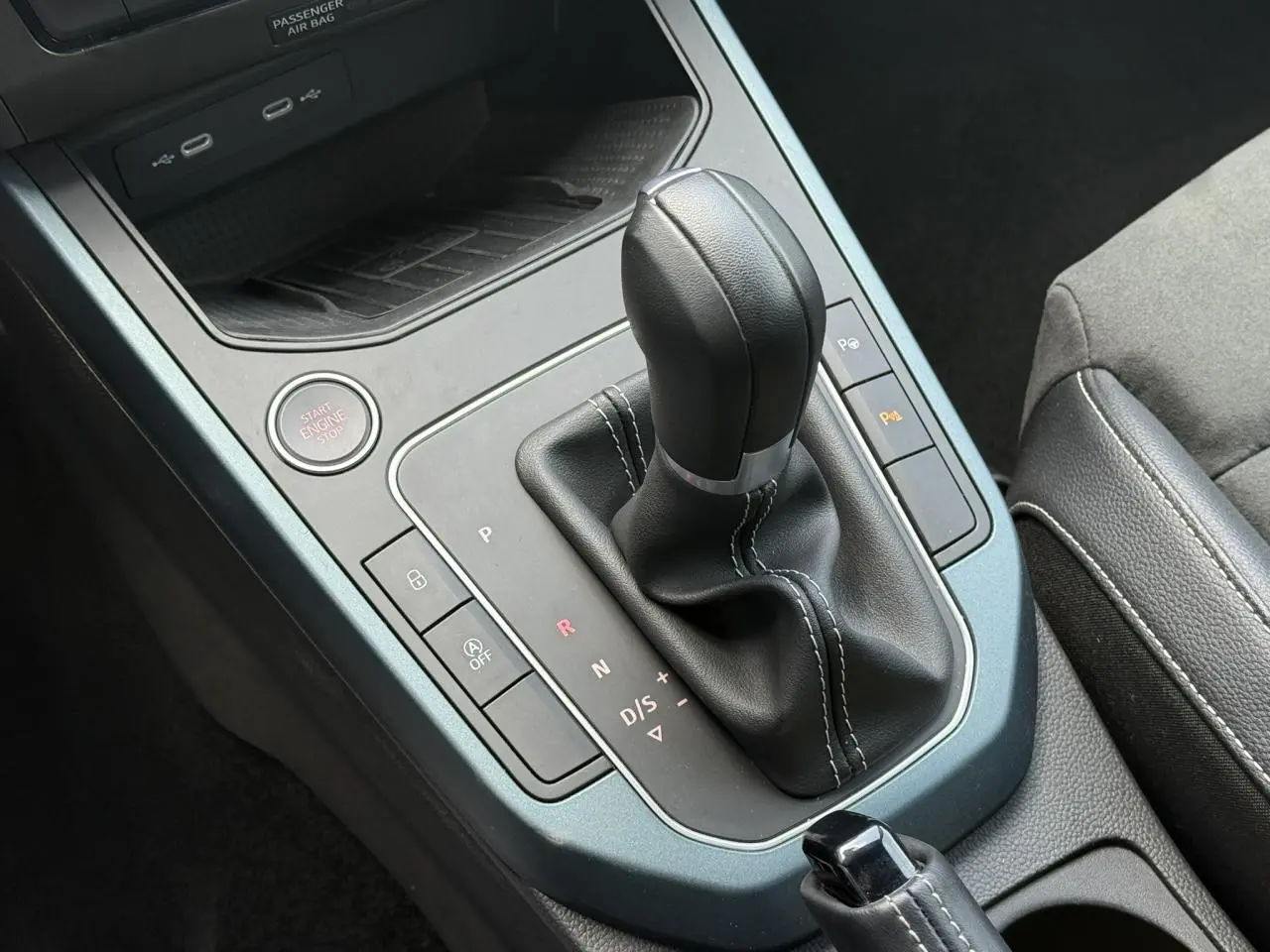 Gros plan sur la console centrale du SEAT Arona gris Cliff 2025, avec levier de vitesse automatique et bouton Start/Stop.