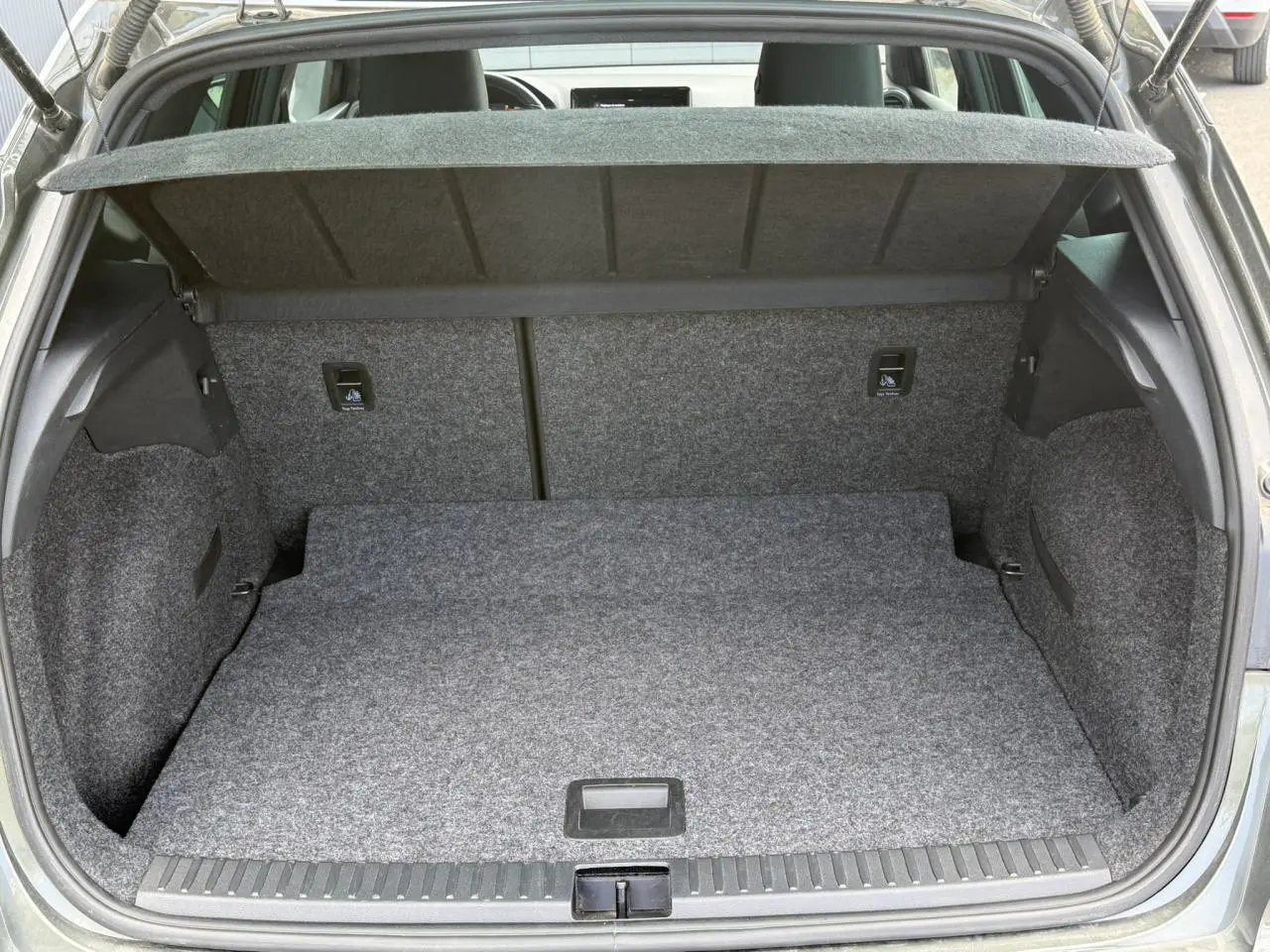 Coffre ouvert vu de l'arrière d'une SEAT Arona Gris Cliff 2025, plancher plat et habillage intérieur gris.