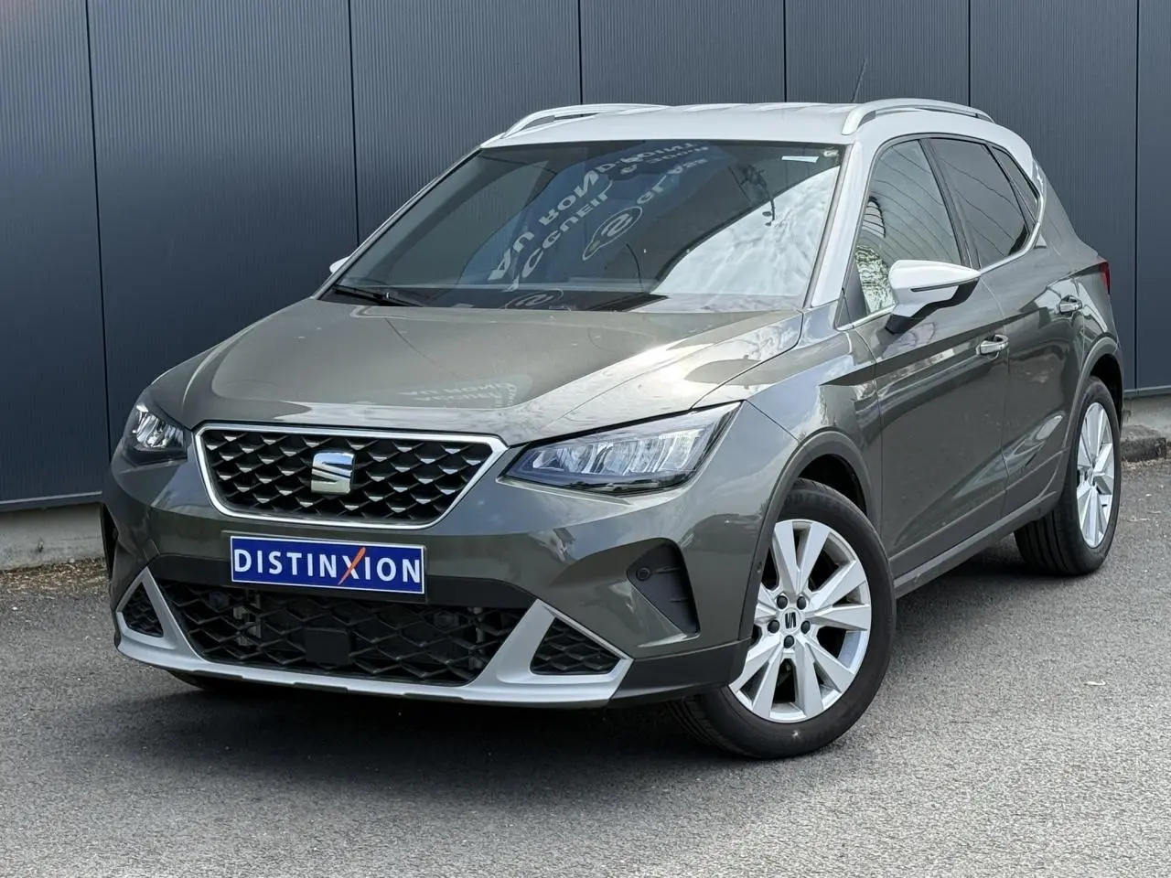 SEAT Arona gris Cliff en 3/4 avant droit, avec calandre chromée et jantes alliage 17 pouces blanches.