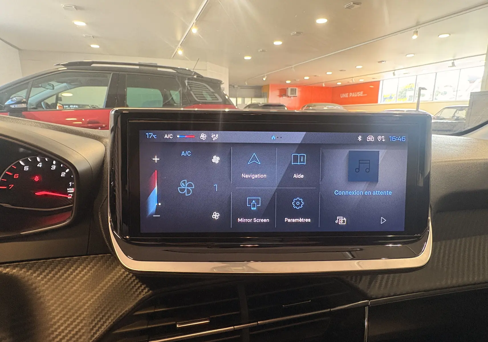 Écran tactile central de la Peugeot 208 Active 2024, affichant les commandes de climatisation et navigation, intérieur noir.