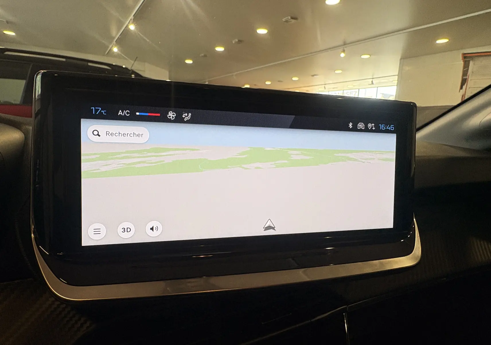 Écran tactile central du tableau de bord de la Peugeot 208 rouge, affichant la navigation GPS en intérieur.