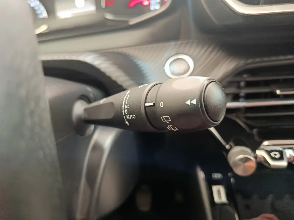Gros plan sur la commande d’essuie-glace côté gauche du tableau de bord intérieur du Peugeot 2008 bleu 2021.