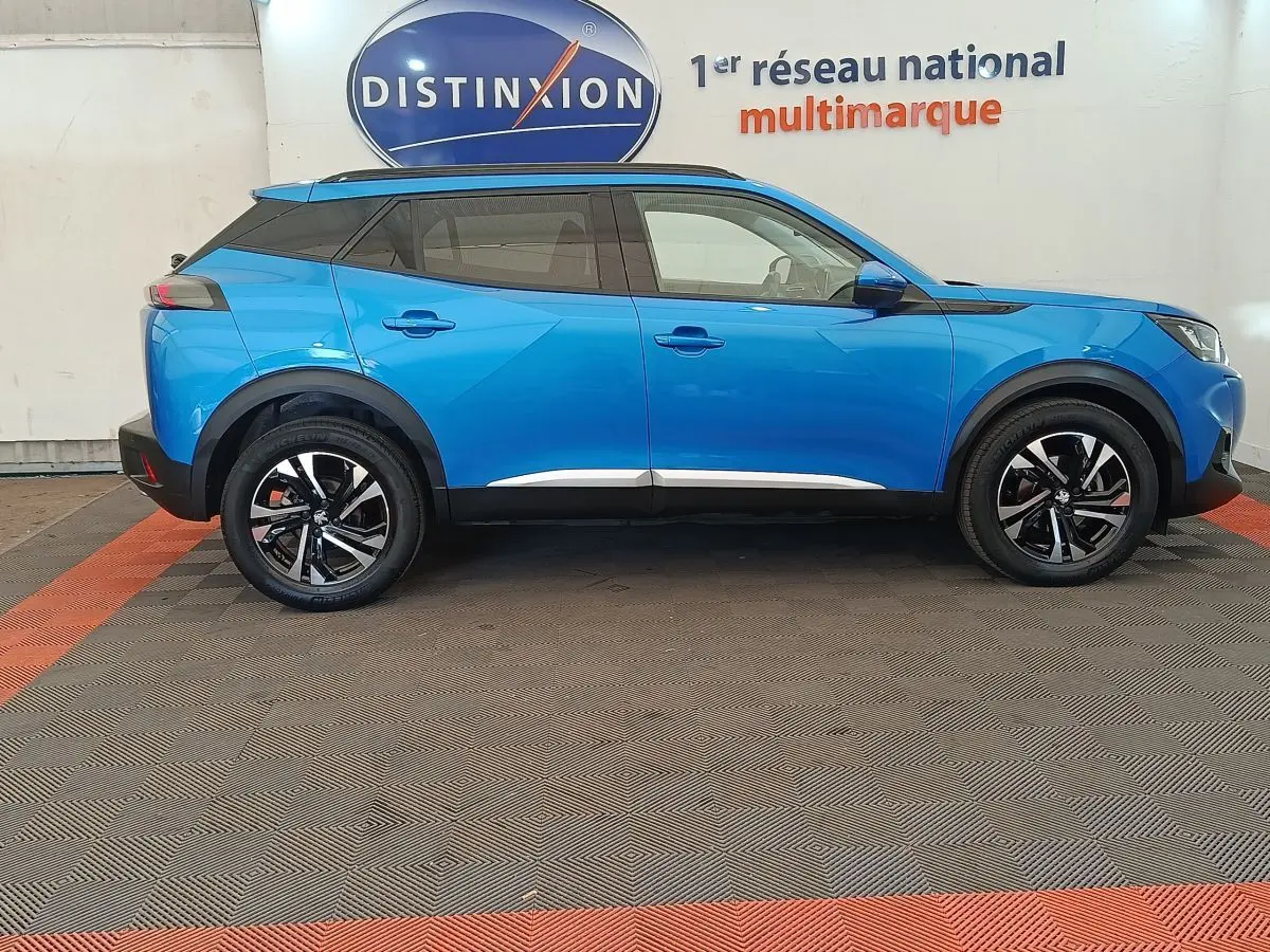 Vue latérale droite d'un Peugeot 2008 bleu 2021 avec jantes noires et toit noir contrastant.