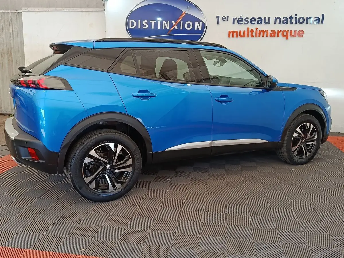 Peugeot 2008 bleu vue de profil côté gauche, avec jantes alliage et toit noir contrastant.