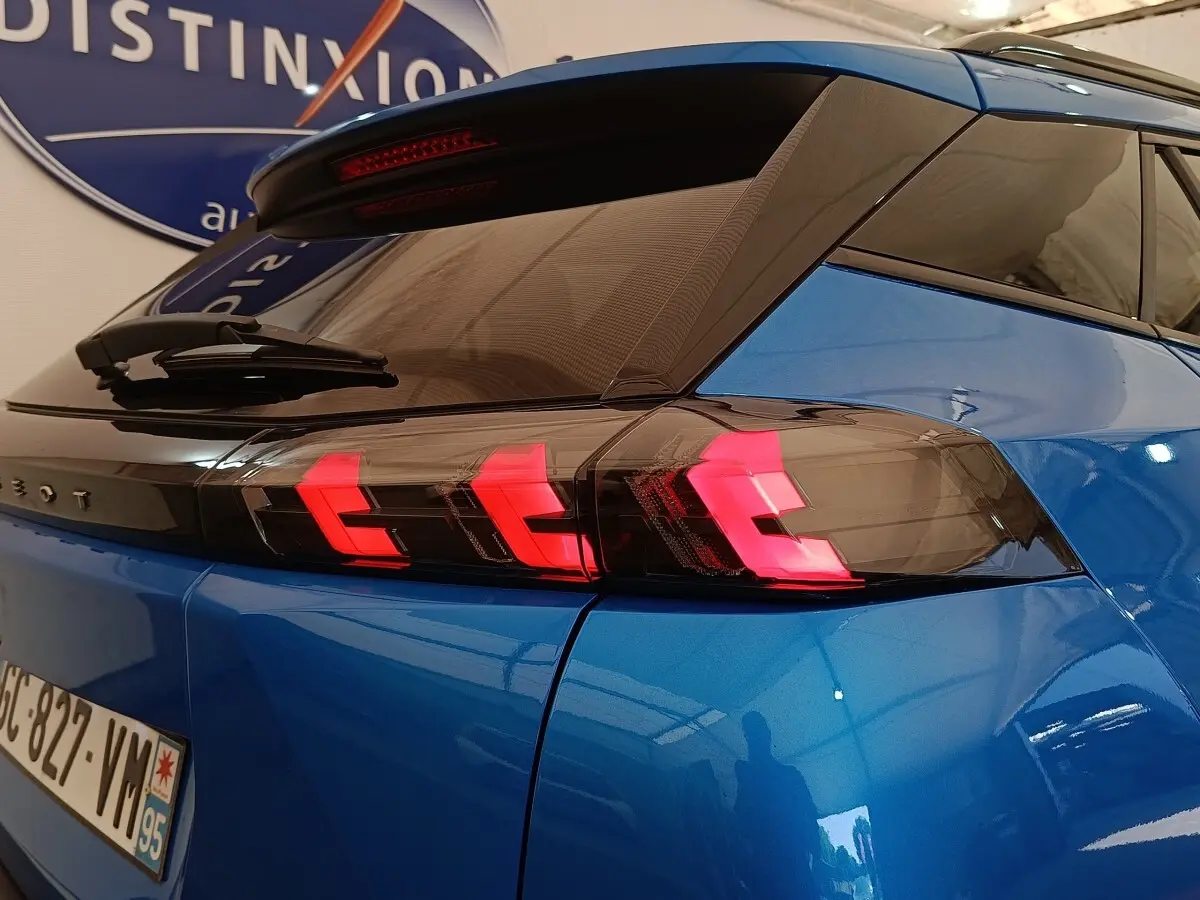 Vue 3/4 arrière du Peugeot 2008 bleu avec feux arrière LED en forme de griffes rouges distinctives.