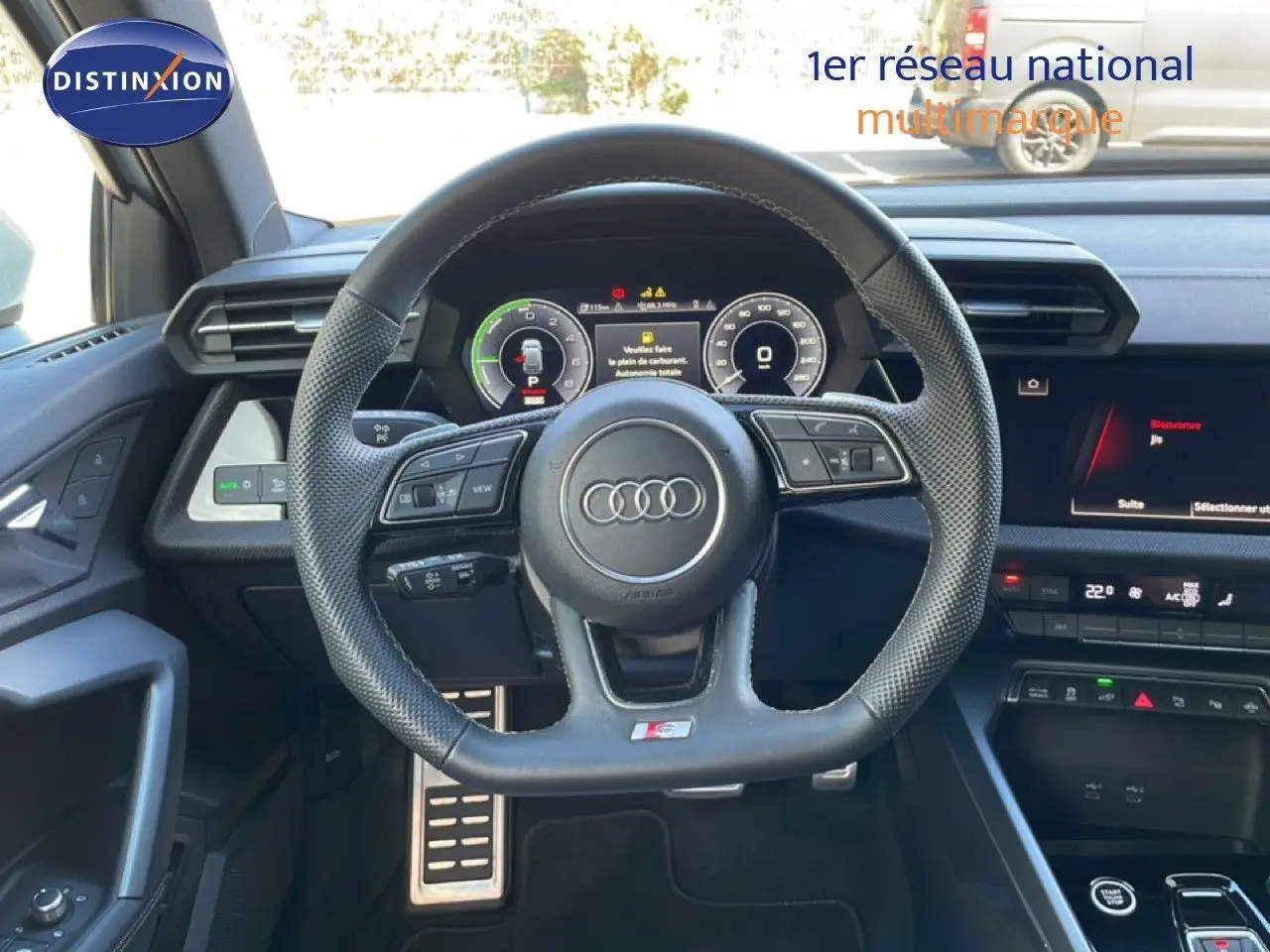 Vue intérieure centrée sur le volant cuir perforé et le tableau de bord numérique de l'Audi A3 Sportback 2025.