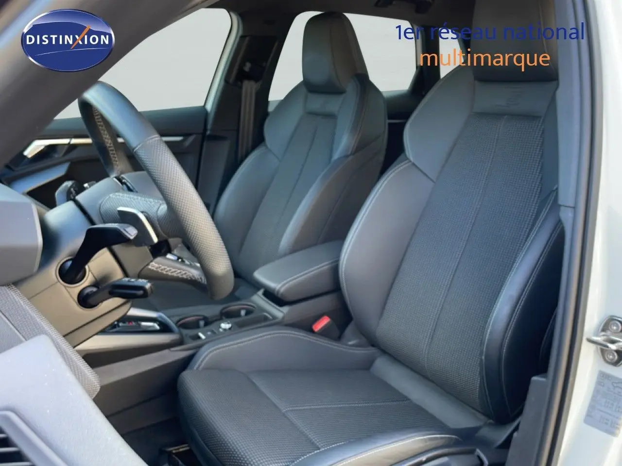 Vue intérieure côté conducteur de l’Audi A3 Sportback 40 TFSIe 2025, sièges gris noir en tissu et cuir, volant multifonction.