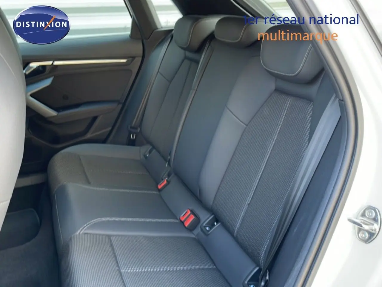 Vue intérieure côté droit des sièges arrière en tissu gris et cuir dans une Audi A3 Sportback blanc Ibis 2025.