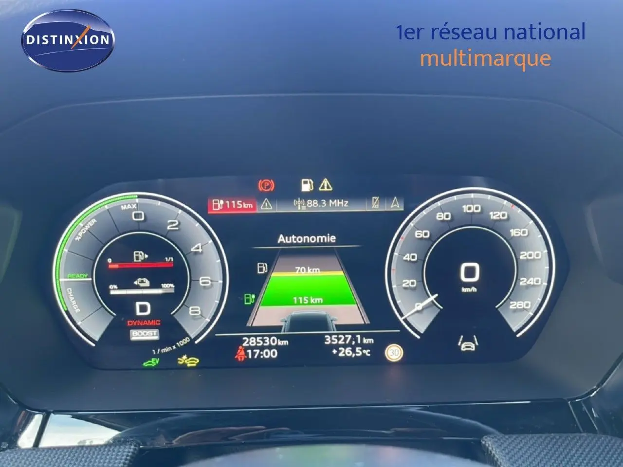 Tableau de bord numérique d'Audi A3 Sportback blanc, affichant autonomie et compteurs à 0 km/h en vue frontale.