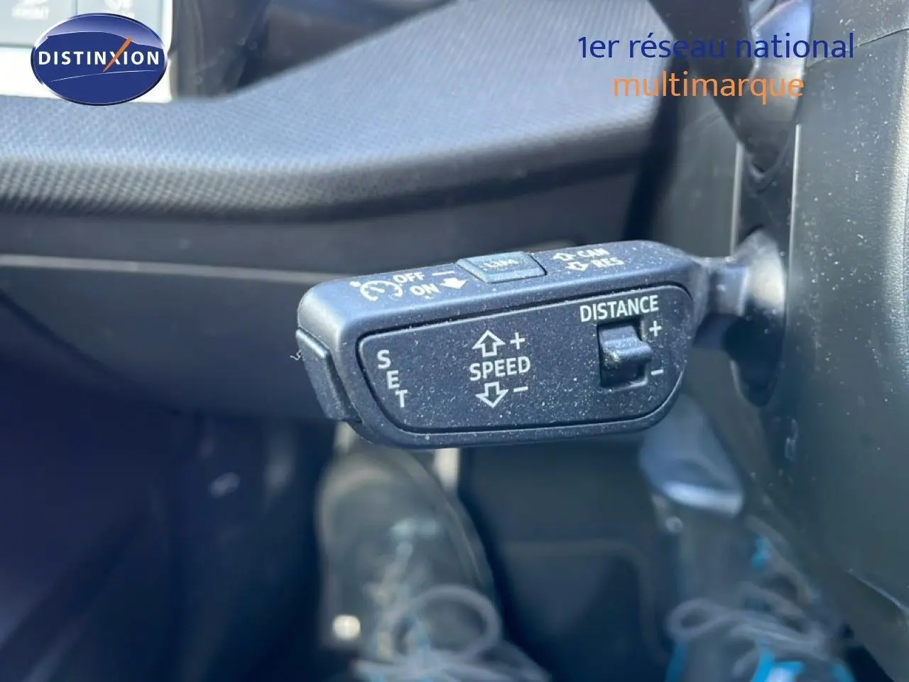Gros plan sur la commande de régulateur de vitesse au volant d’une Audi A3 Sportback blanc Ibis 2025.