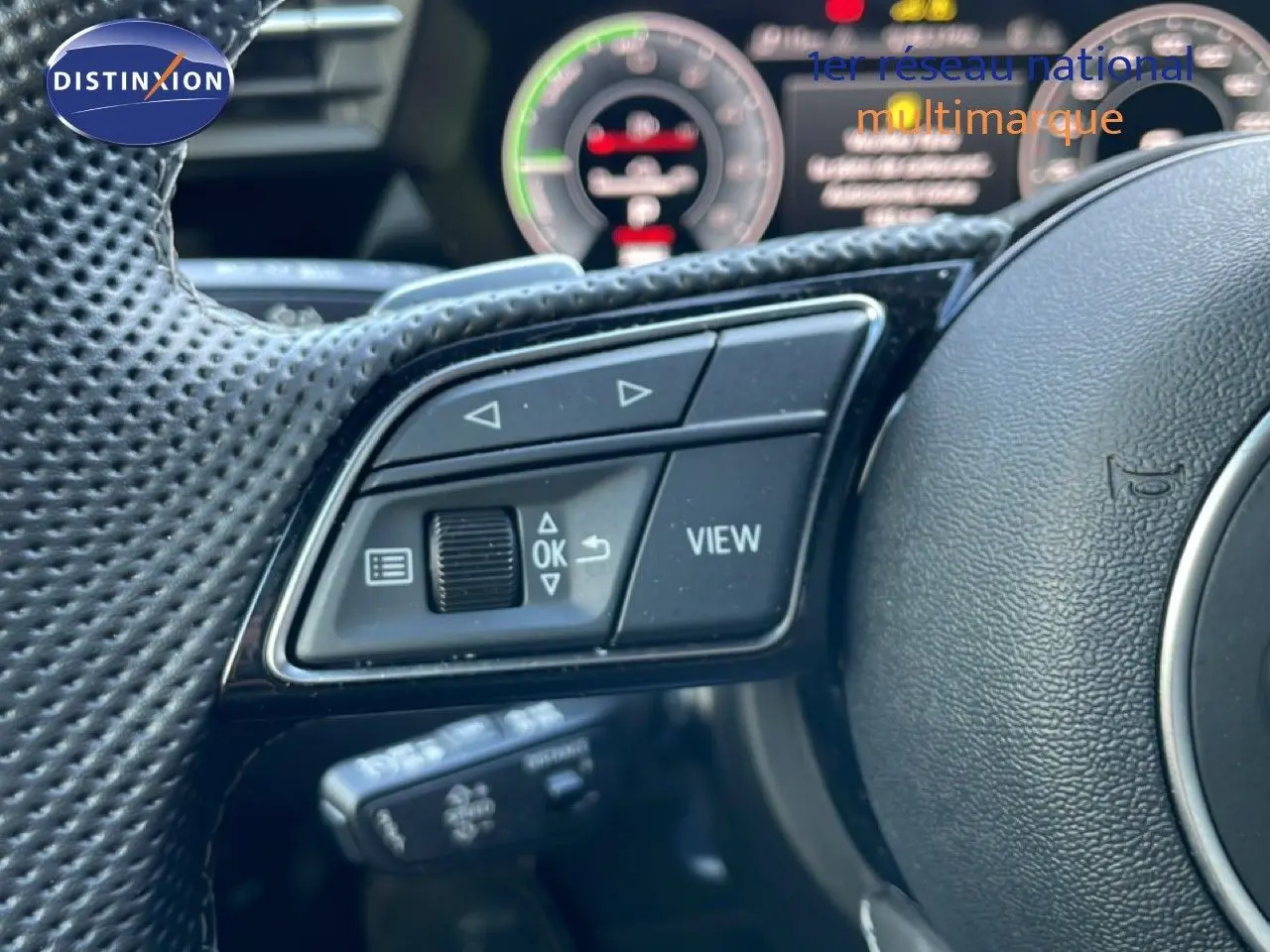 Gros plan sur les commandes multifonctions du volant côté gauche d’une Audi A3 Sportback blanc Ibis 2025.