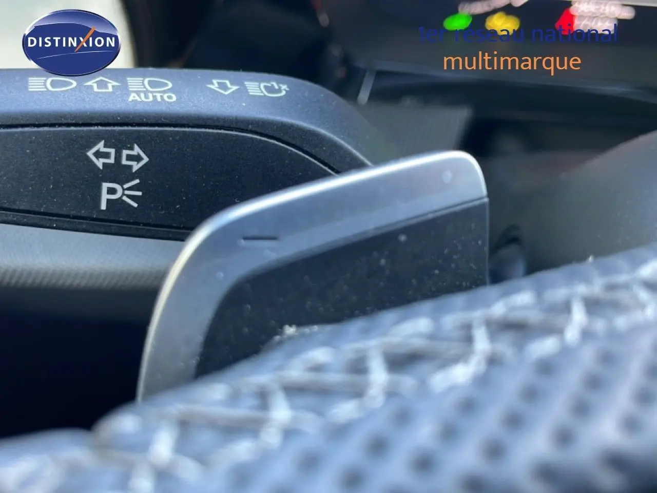 Gros plan sur la palette de changement de vitesse et le commodo des clignotants dans l'habitacle d'un Audi A3 Sportback blanc ibis.