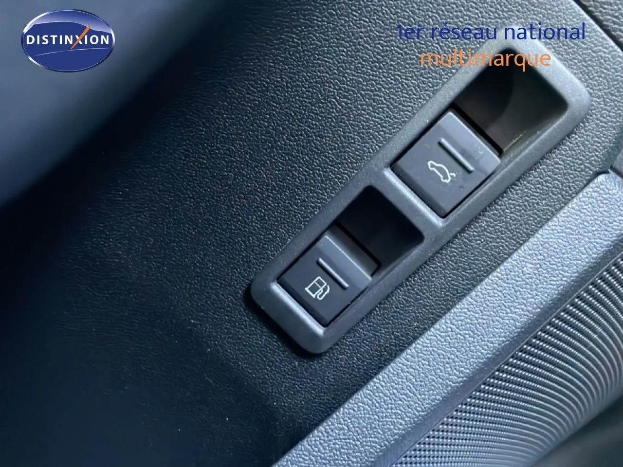 Gros plan sur les boutons d'ouverture de la trappe à carburant et du coffre dans l'habitacle noir d'une Audi A3 Sportback blanche.