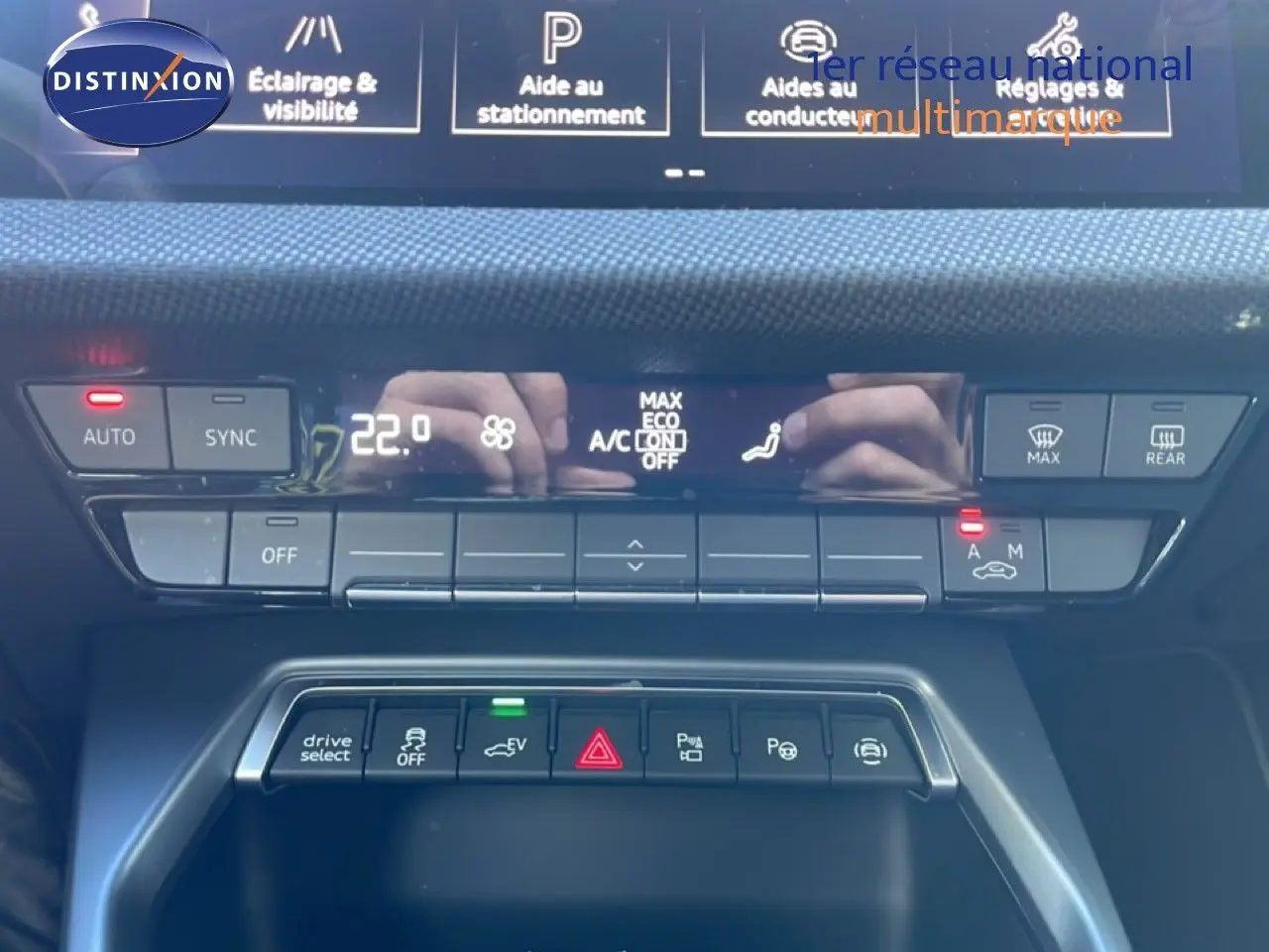 Vue rapprochée du tableau de bord de l'Audi A3 Sportback blanc Ibis 2025, mettant en valeur les commandes climatisation et aides à la conduite.