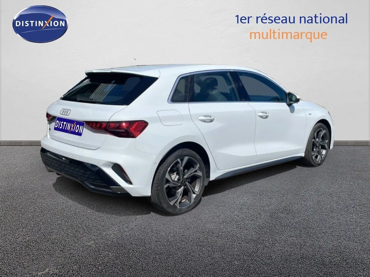 Audi A3 Sportback blanc Ibis vue 3/4 arrière droit, roues alliage noires et vitres teintées.
