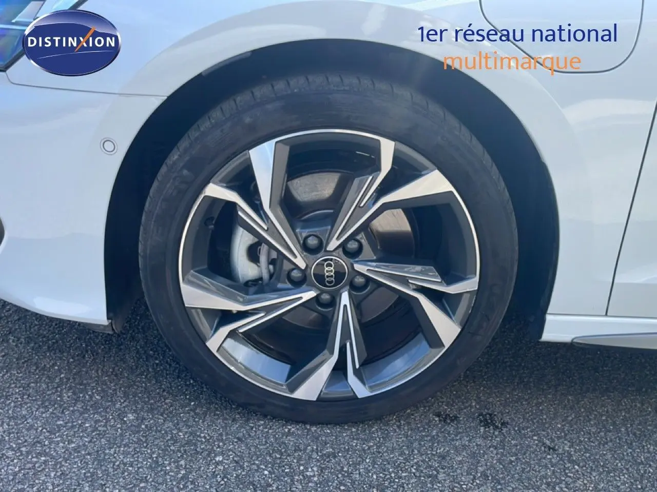 Gros plan sur la roue avant droite d’une Audi A3 Sportback blanc ibis avec jante alliage au design moderne.