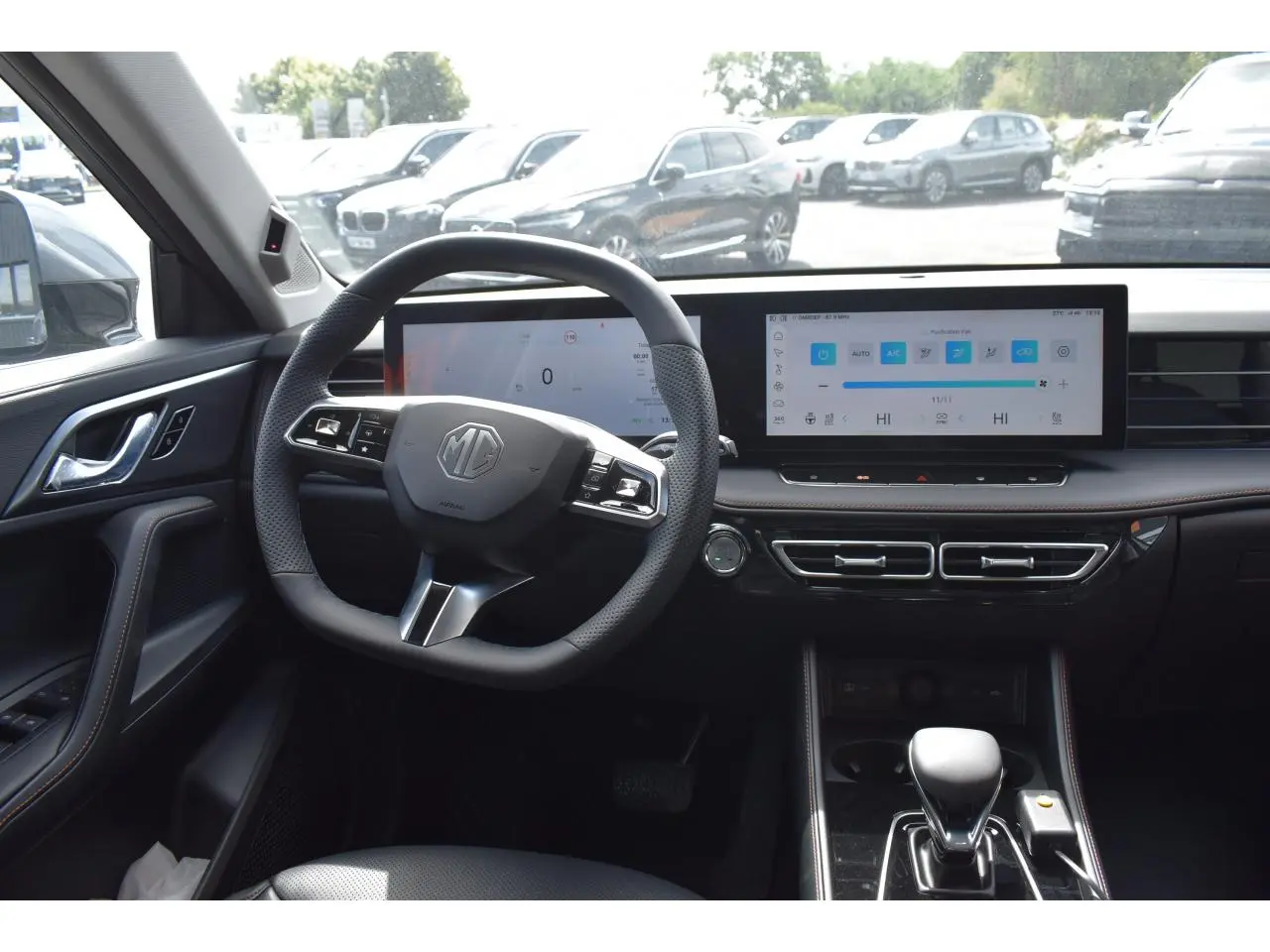 Vue intérieure du poste de conduite du MG Motor EHS gris 2026, avec volant multifonction et grand écran tactile horizontal.