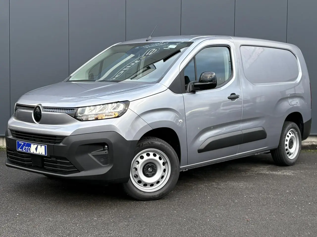 Vue 3/4 avant droit d'un Citroën Berlingo Van XL gris Artense avec calandre noire et jantes tôles 16 pouces.