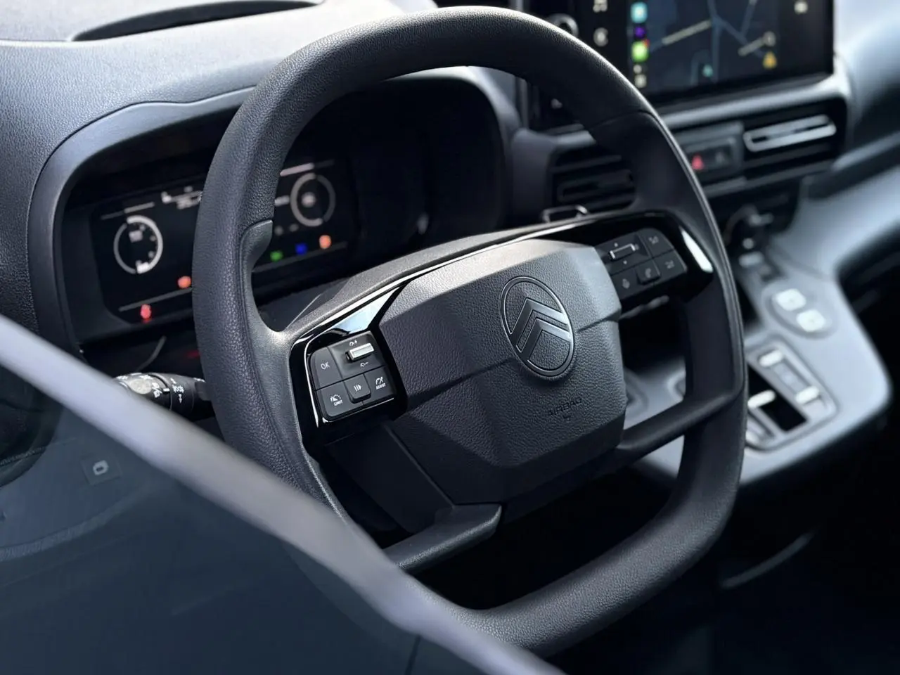 Volant multifonctions noir vu de près dans l'habitacle du Citroën Berlingo Van XL 2025 avec tableau de bord numérique.