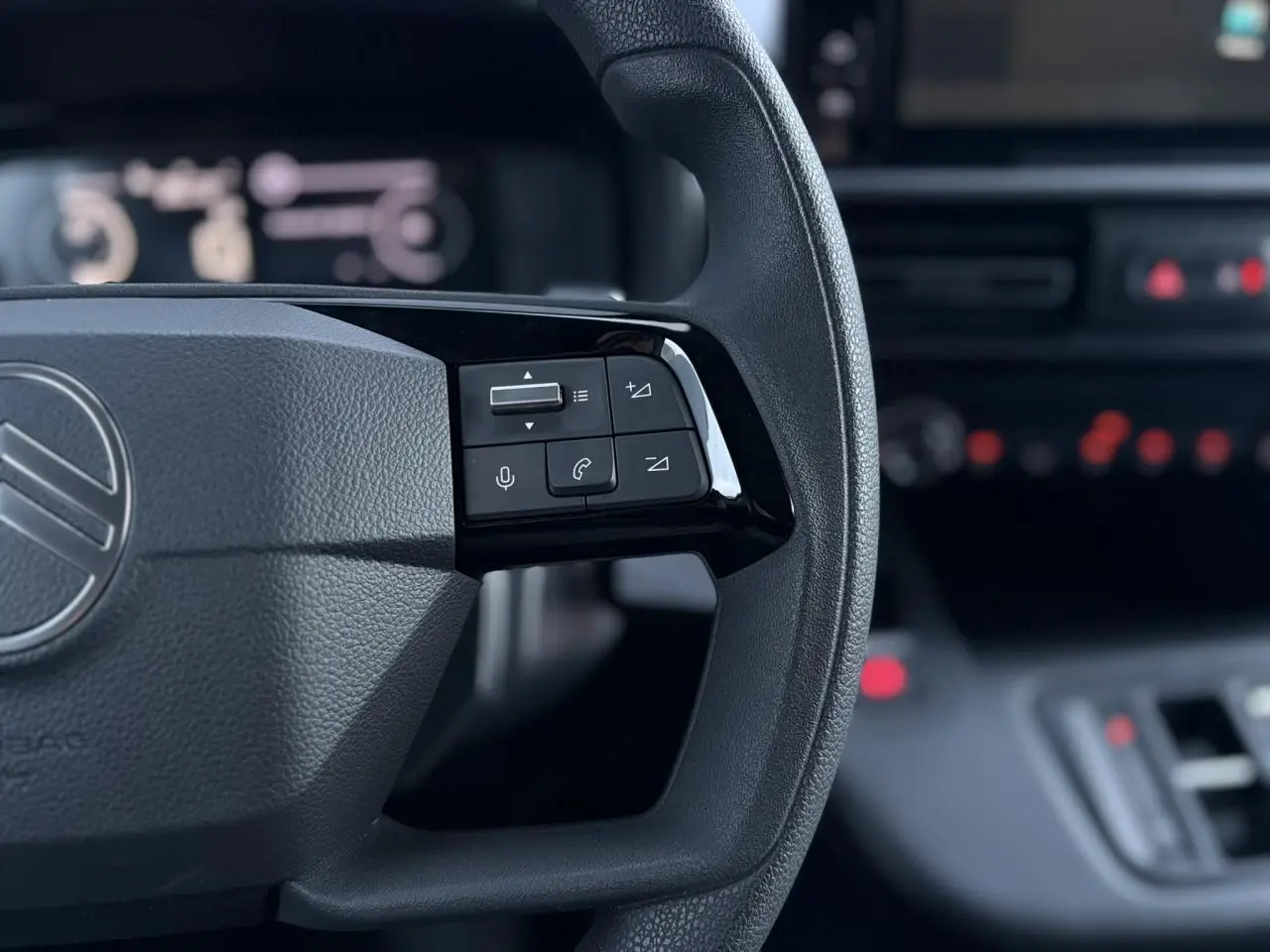 Gros plan sur le volant multifonctions noir du Citroën Berlingo 2025 avec commandes audio et téléphone intégrées.