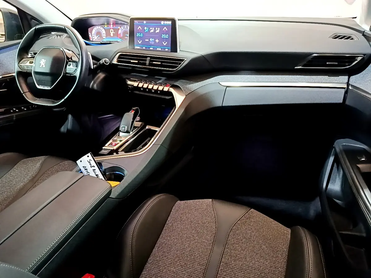 Intérieur du Peugeot 5008 2020 vu côté passager, tableau de bord noir avec écran tactile et volant compact cuir.