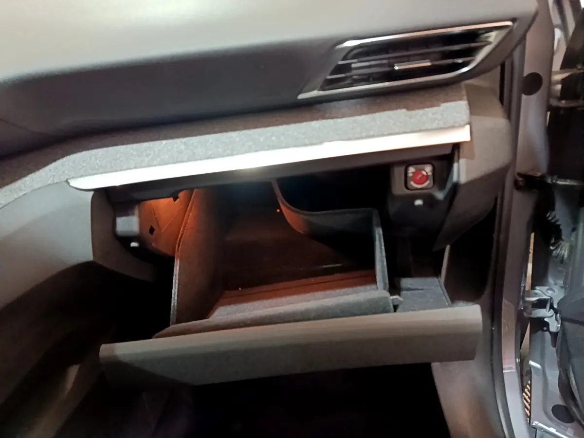 Intérieur du Peugeot 5008 gris clair 2020, vue sur la boîte à gants ouverte côté passager avec éclairage intérieur.