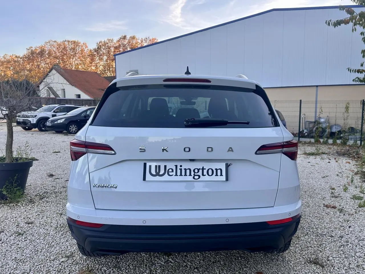Vue arrière d'un Skoda Karoq blanc 2024 avec feux arrière LED et logo ŠKODA bien visible.