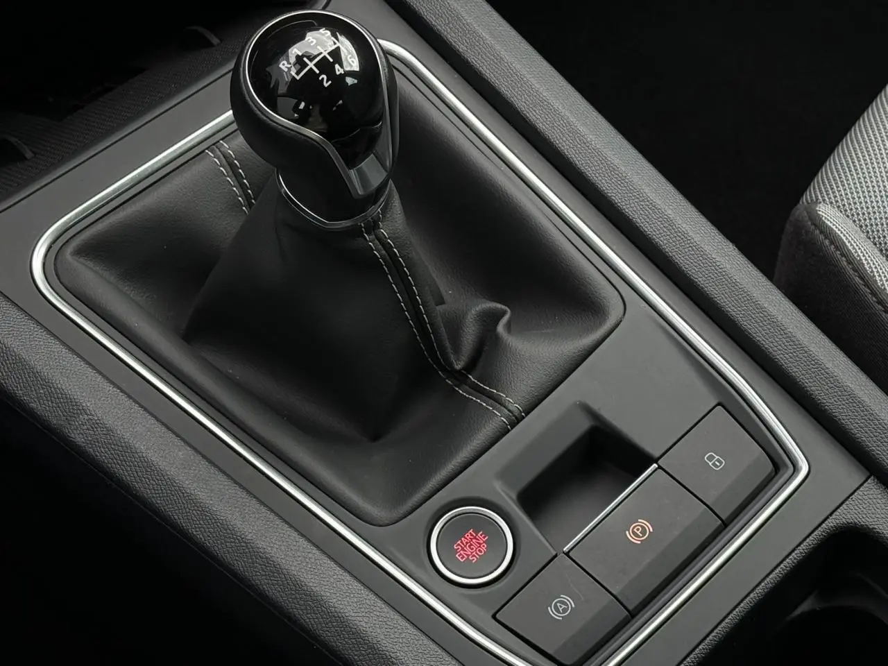 Gros plan sur levier de vitesse manuel noir et bouton start/stop rouge dans l’habitacle d’une SEAT Leon 2025.
