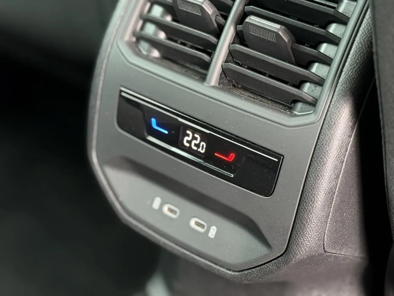 Détail du panneau de climatisation arrière avec affichage digital et ports USB-C dans une SEAT Leon noir Minuit.