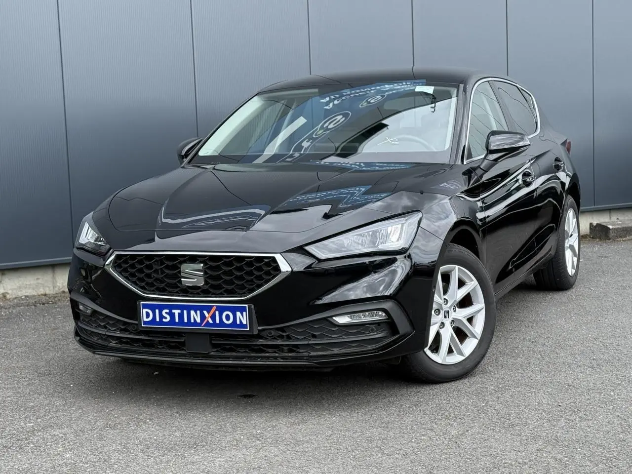 SEAT Leon noir Minuit vue 3/4 avant droit, jantes alliage argent et calandre hexagonale distinctive.