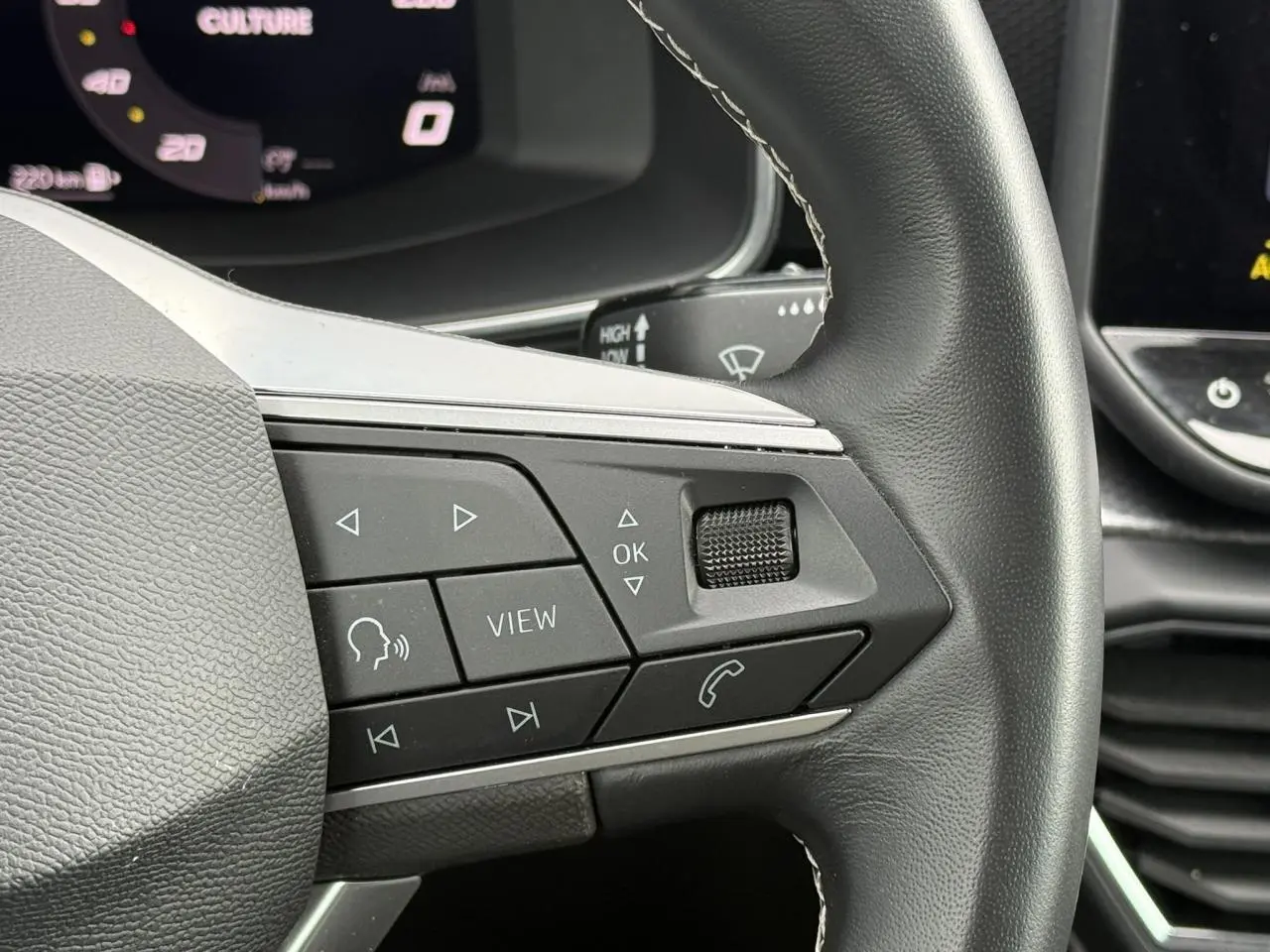 Gros plan sur les commandes multifonctions du volant cuir noir de la SEAT LEON 2025, version 2.0 TDI Style.