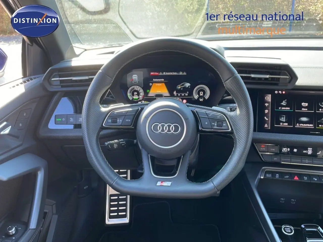 Vue intérieure centrée sur le volant S-Line et le tableau de bord numérique de l'Audi A3 Sportback 2025.