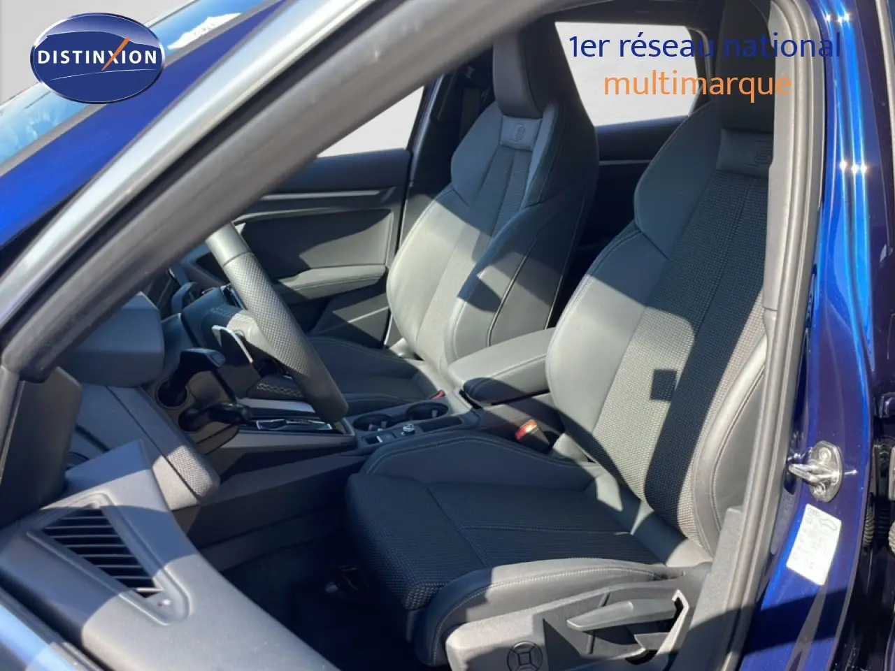 Vue intérieure côté conducteur de l'Audi A3 Sportback 40 TFSIe S-Line 2025 en bleu Navarre, sièges sport gris foncé.