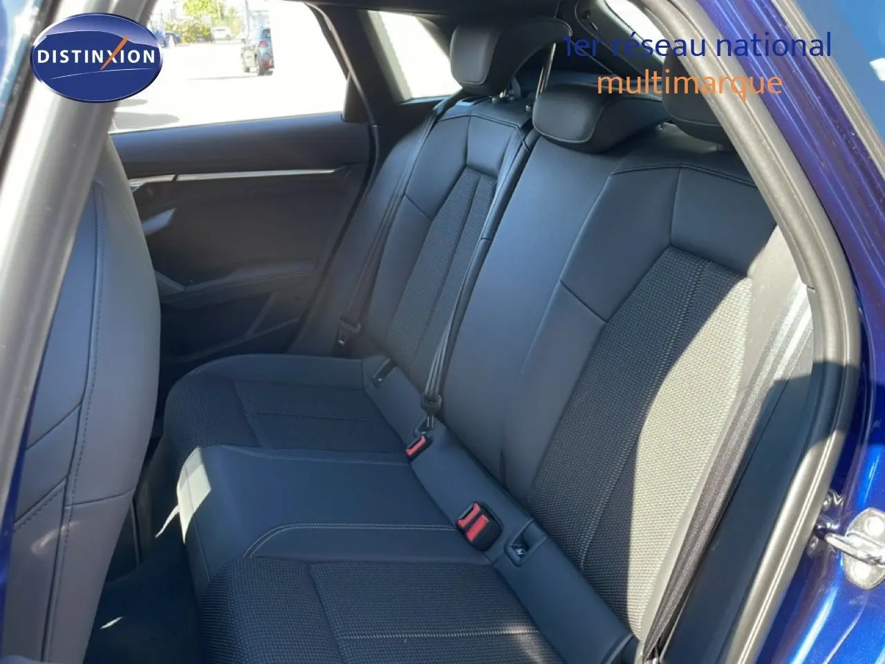 Vue intérieure côté arrière droit montrant les sièges arrière en tissu gris foncé d'une Audi A3 Sportback Bleu Navarre 2025.