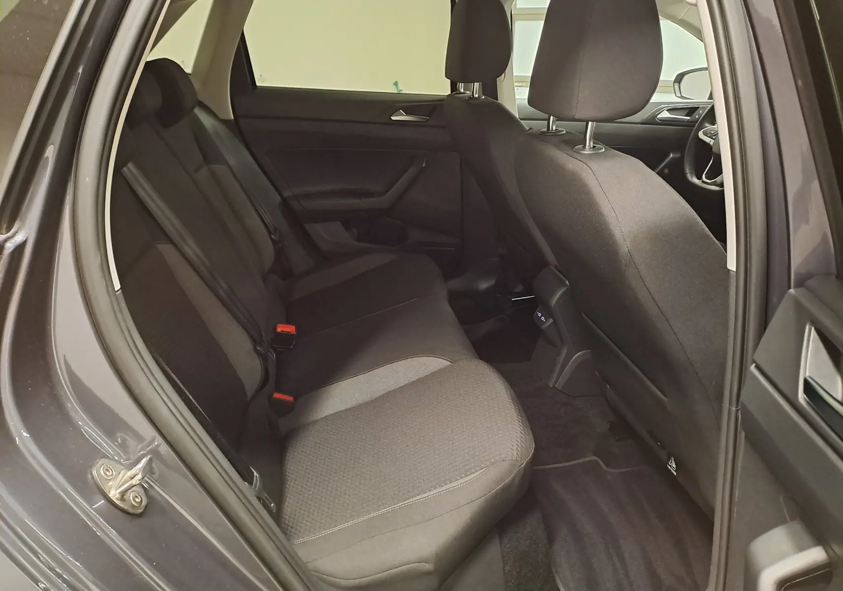 Vue intérieure côté gauche des sièges arrière en tissu noir d'une Volkswagen Polo gris cendre 2025, version VW Edition.