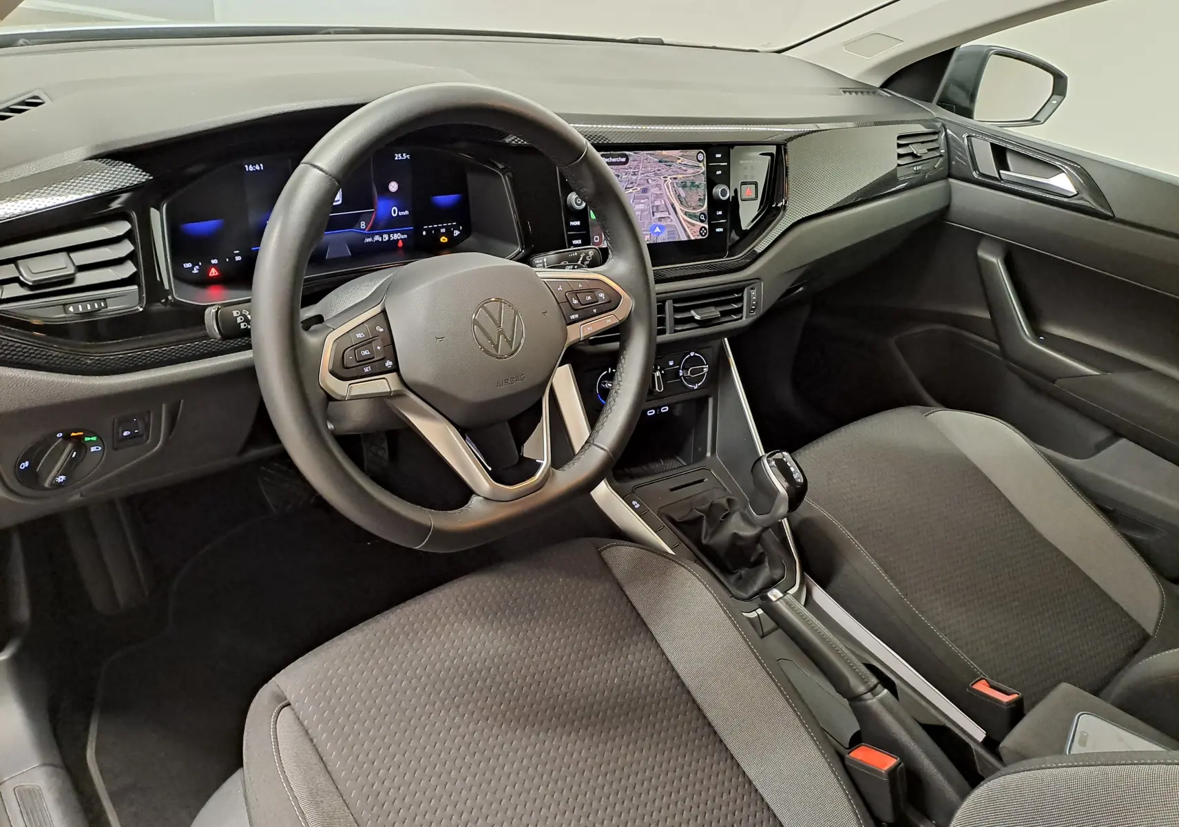 Vue intérieure côté conducteur de la Volkswagen Polo 2025, tableau de bord moderne avec écran tactile et volant multifonction noir.