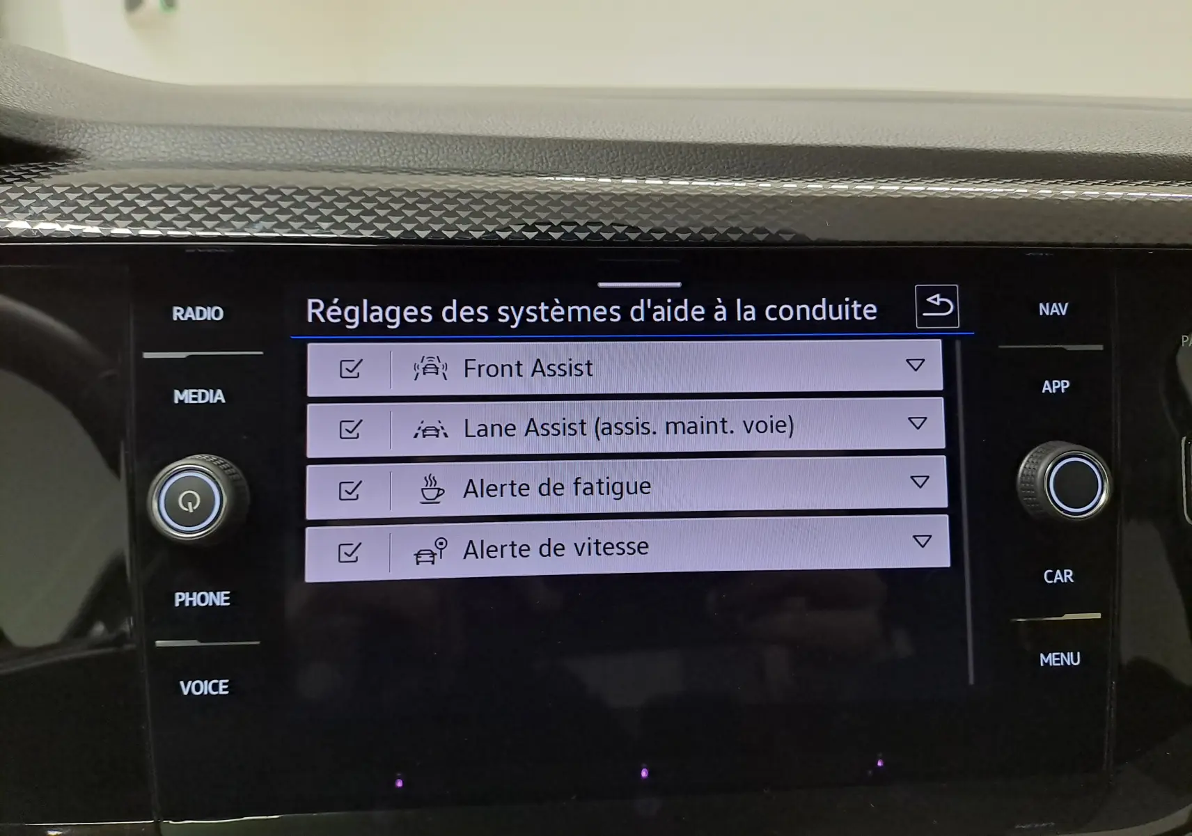 Écran tactile central de la Volkswagen Polo gris cendre 2025, affichant les réglages des aides à la conduite.