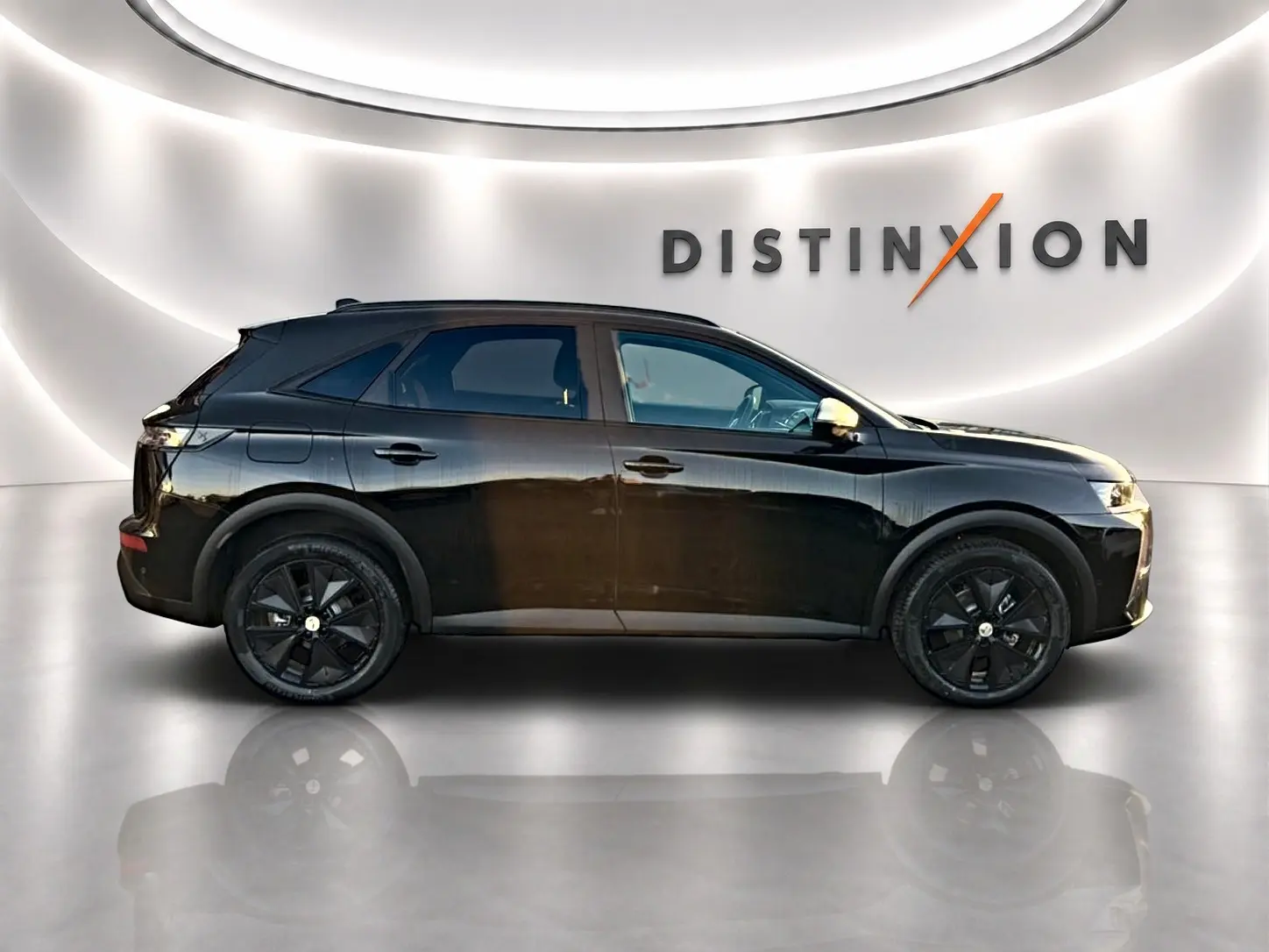 Vue de profil côté gauche du DS7 noir 1.5 BlueHDi 130 Performance Line avec jantes noires dans un showroom lumineux.