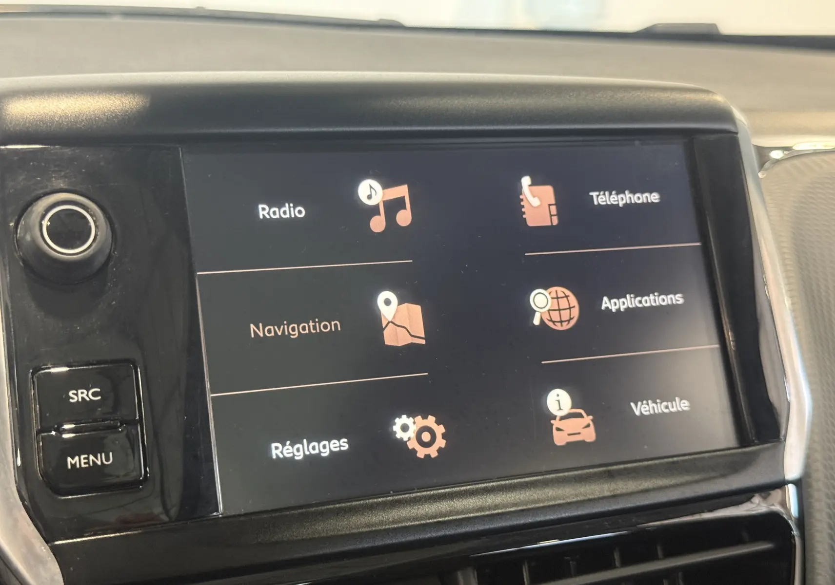 Écran tactile central du Peugeot 2008 blanc 2018 affichant les options radio, navigation, téléphone et réglages.