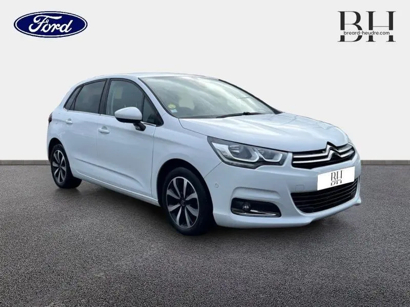 Citroën C4 blanc vue 3/4 avant droit avec jantes alliage et feux LED diurnes allumés.