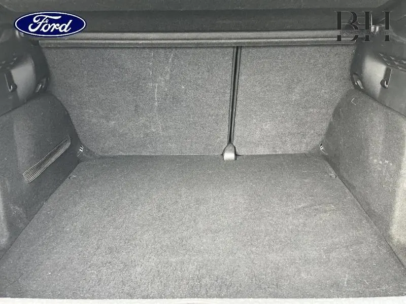 Coffre vide vu de face, revêtement gris foncé, sans objet ni accessoire visible, intérieur spacieux.