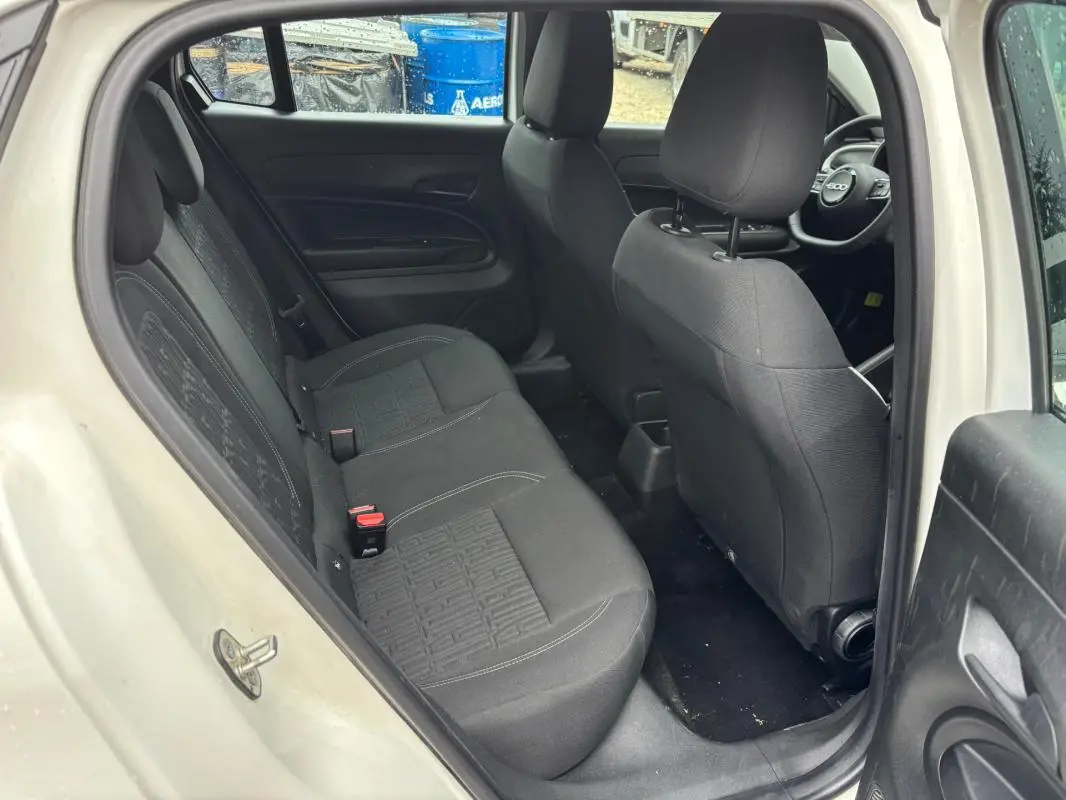 Vue intérieure arrière côté gauche du Fiat 600 blanc 2024, montrant les sièges noirs et l'habitacle spacieux.