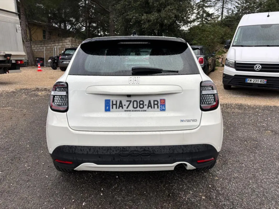 Vue arrière d'une FIAT 600 blanche 2024 avec feux arrière à motifs LED et logo hybride visible.