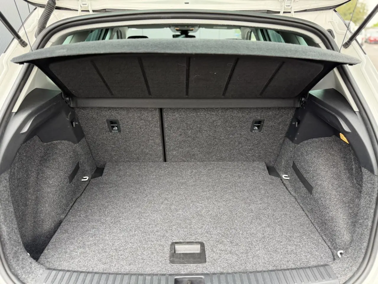 Coffre ouvert en vue arrière d'un SEAT Arona blanc, montrant un espace de rangement propre et bien fini.