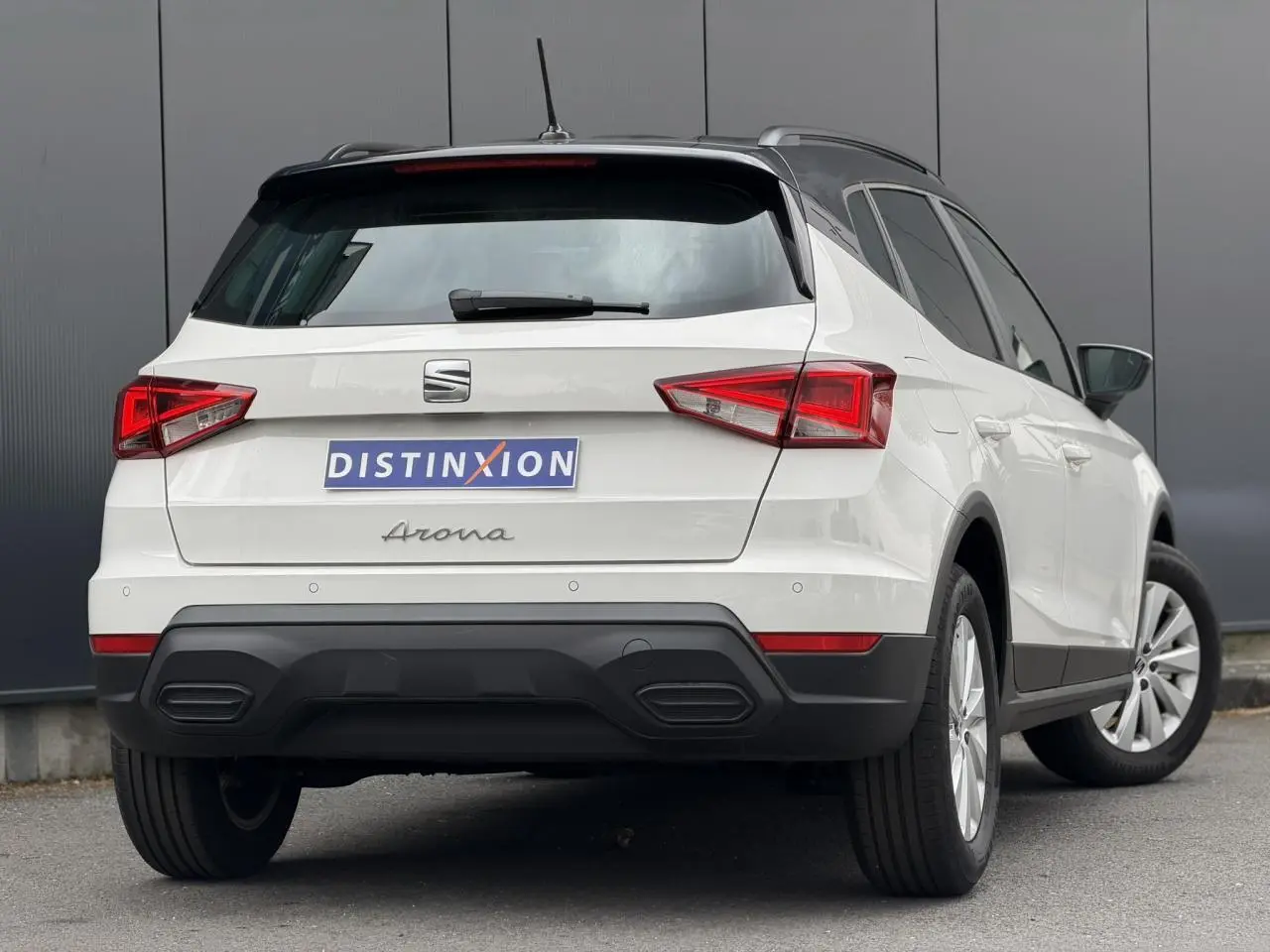 Vue 3/4 arrière droite du SEAT Arona blanc avec toit noir, feux arrière LED et jantes alliage 16 pouces.