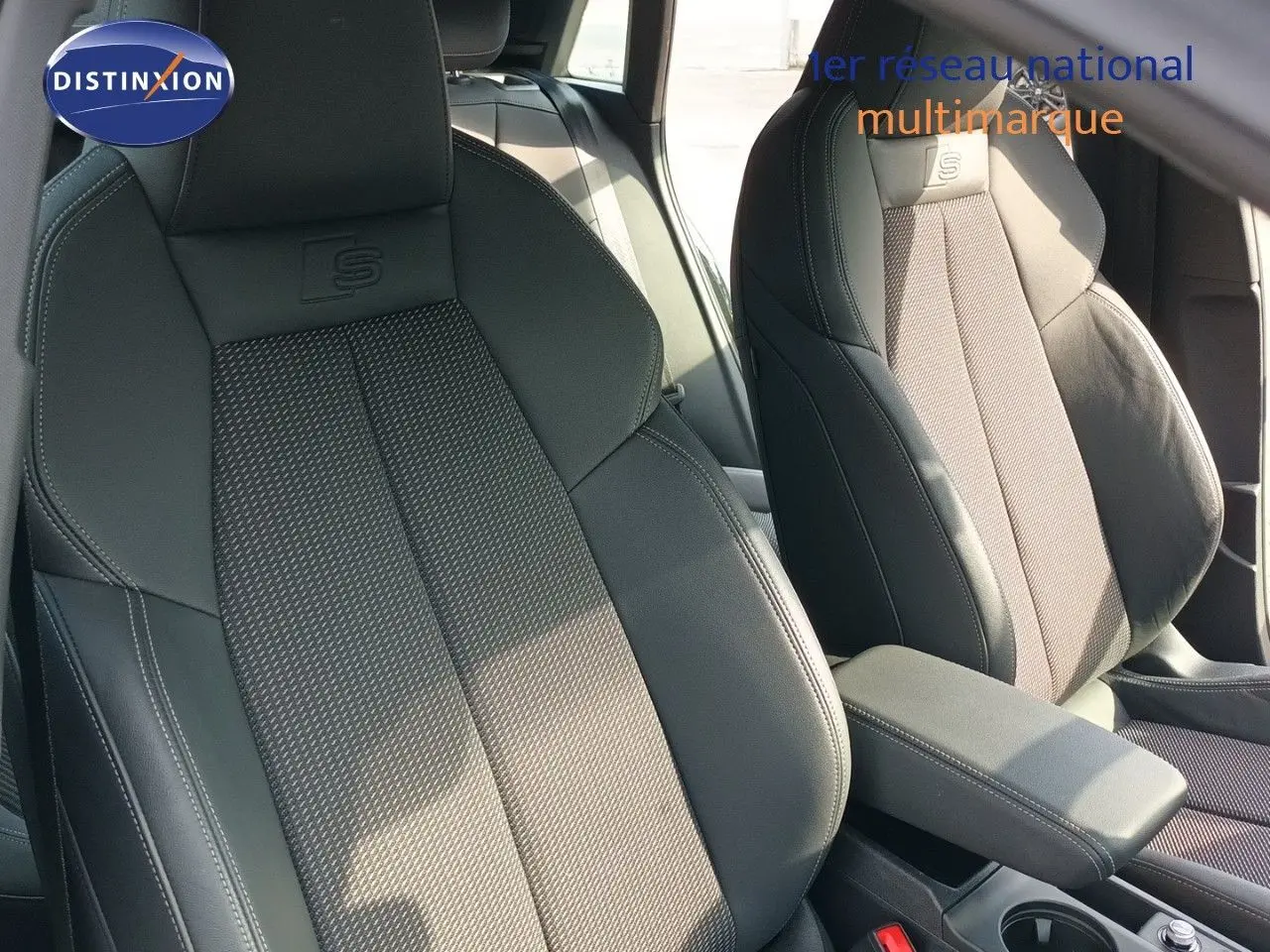Gros plan sur les sièges avant en cuir et tissu gris noir avec logo S embossé, intérieur de l'Audi A3 Sportback 2025.