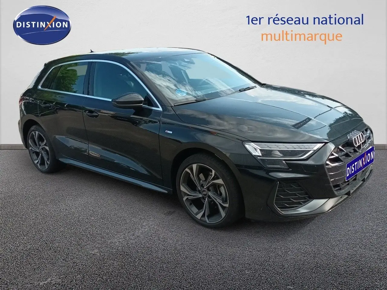 Audi A3 Sportback noir mito metal en 3/4 avant droit, mettant en valeur ses jantes et son design S-Line.