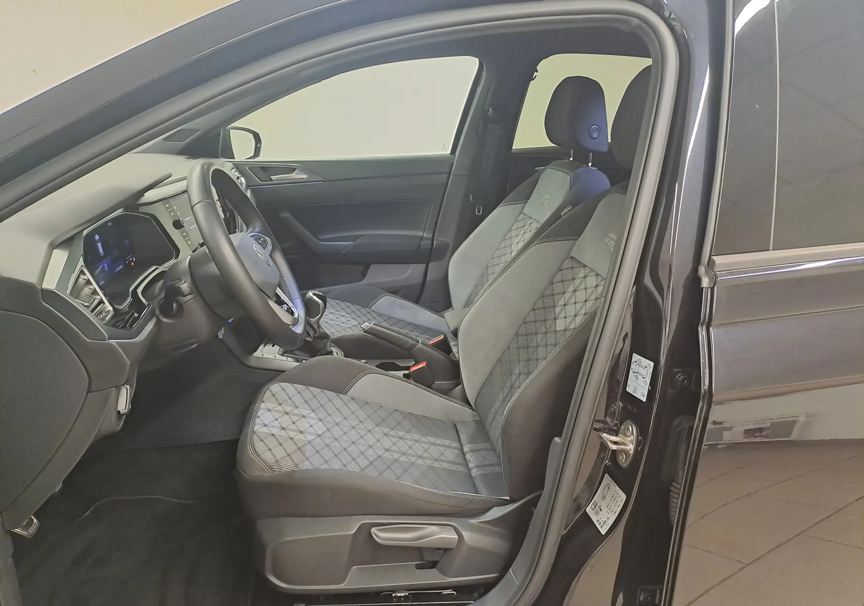Vue intérieure côté conducteur de la Volkswagen Polo Noir Intense 2025 avec sièges tissu et alcantara R-Line.